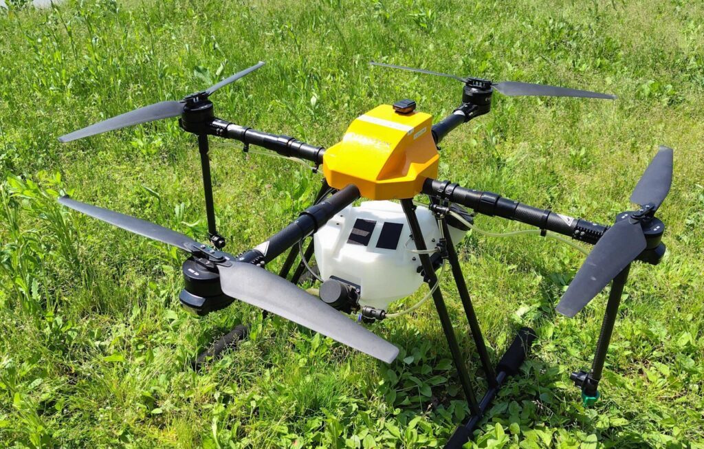 農業用農薬散布ドローンが草地に置かれています